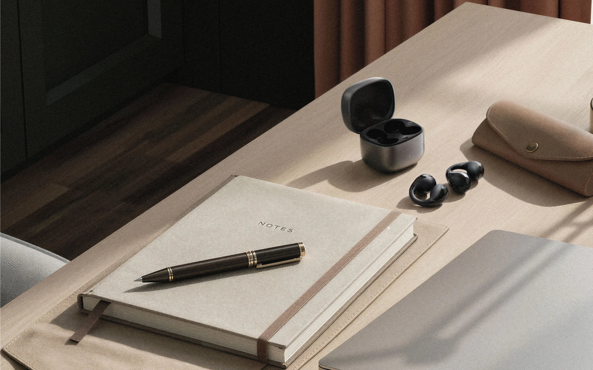 Desk workspace with C-Flow earbuds